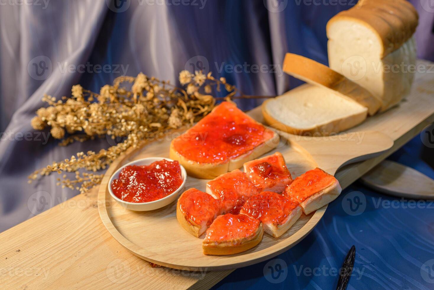 A wooden plate with bread, jam and jelly photo