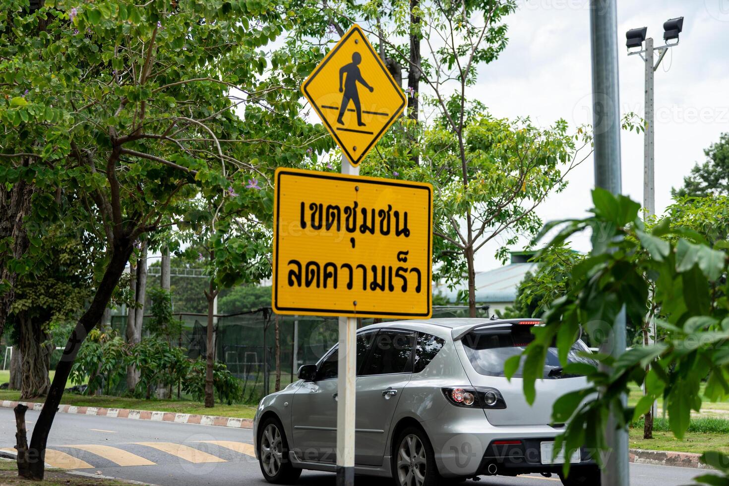 A car driving down a street with a sign that says cross walk photo