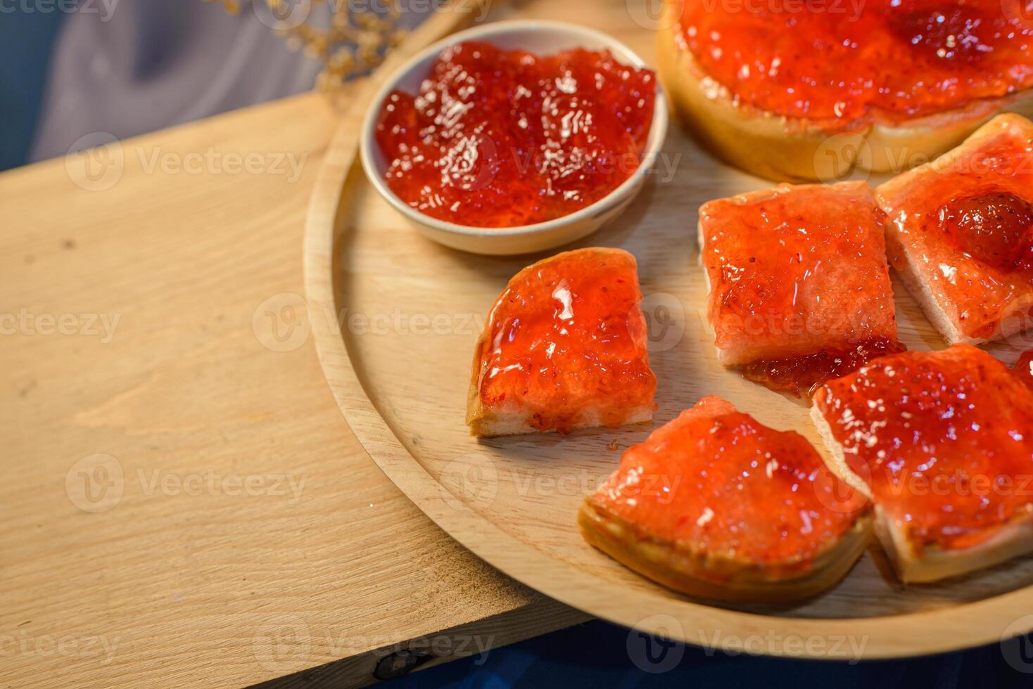A wooden plate topped with bread and jam photo