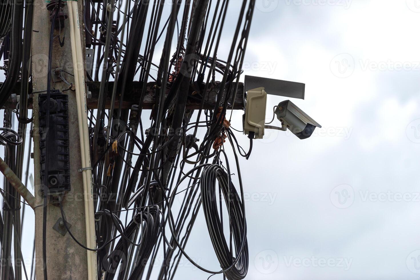 A bunch of wires and a camera on a pole photo
