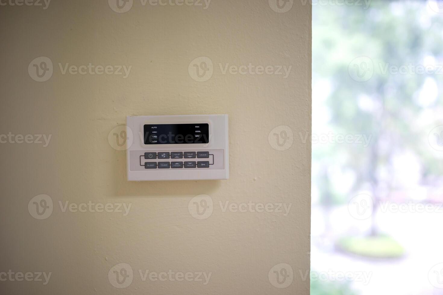 A white alarm clock on a wall in a room photo