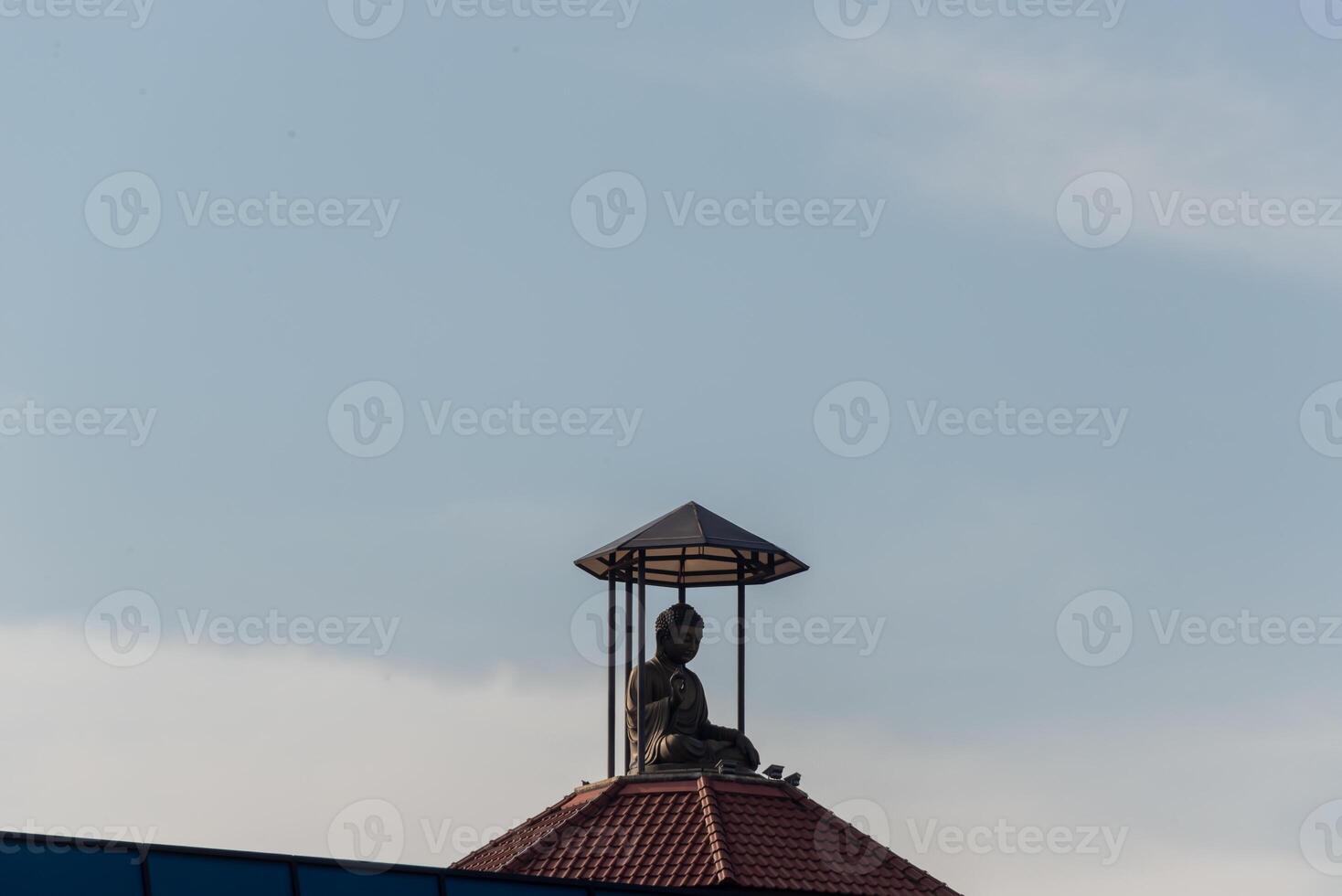 A statue of a buddha on top of a building photo