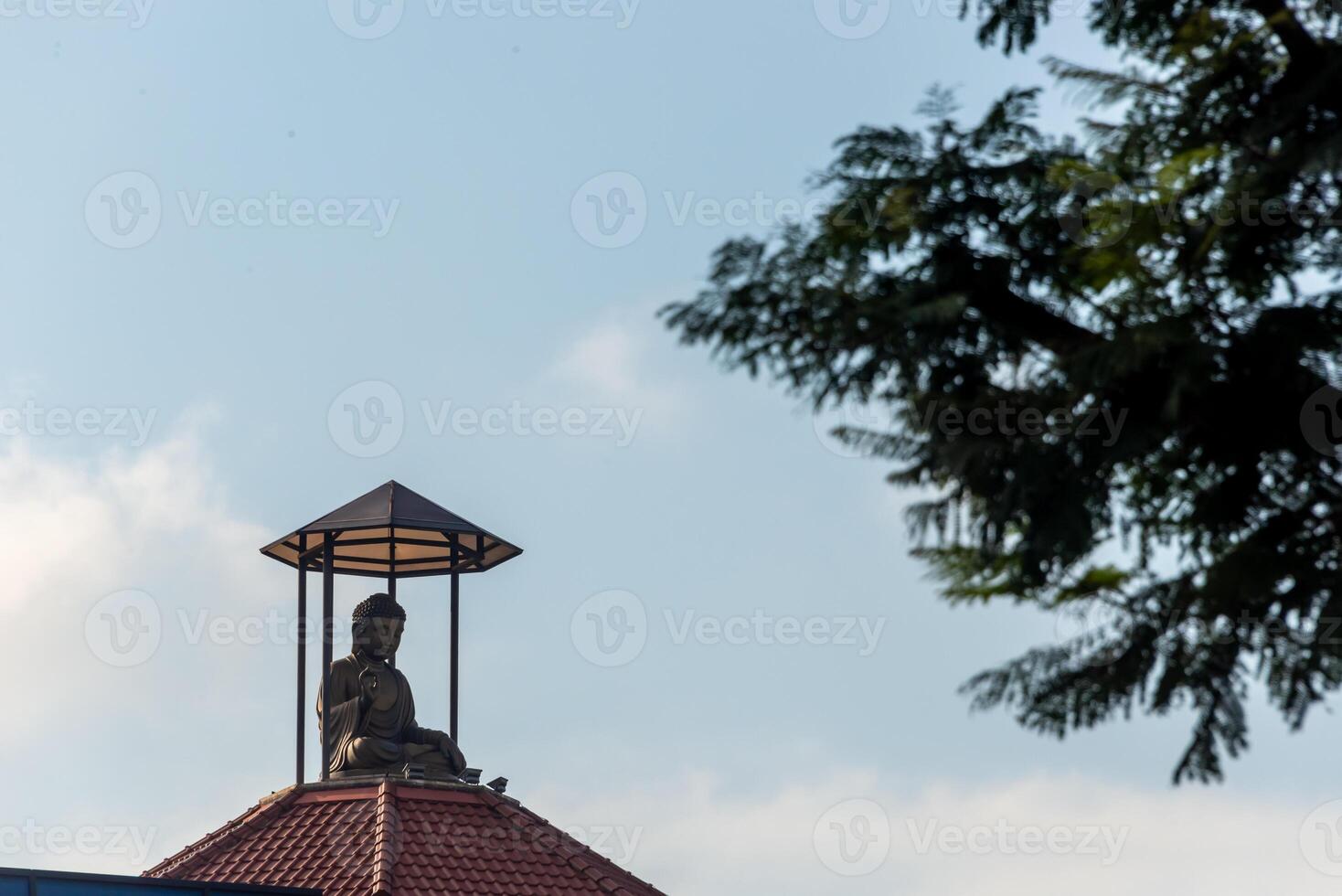 A statue of buddha on top of a building photo