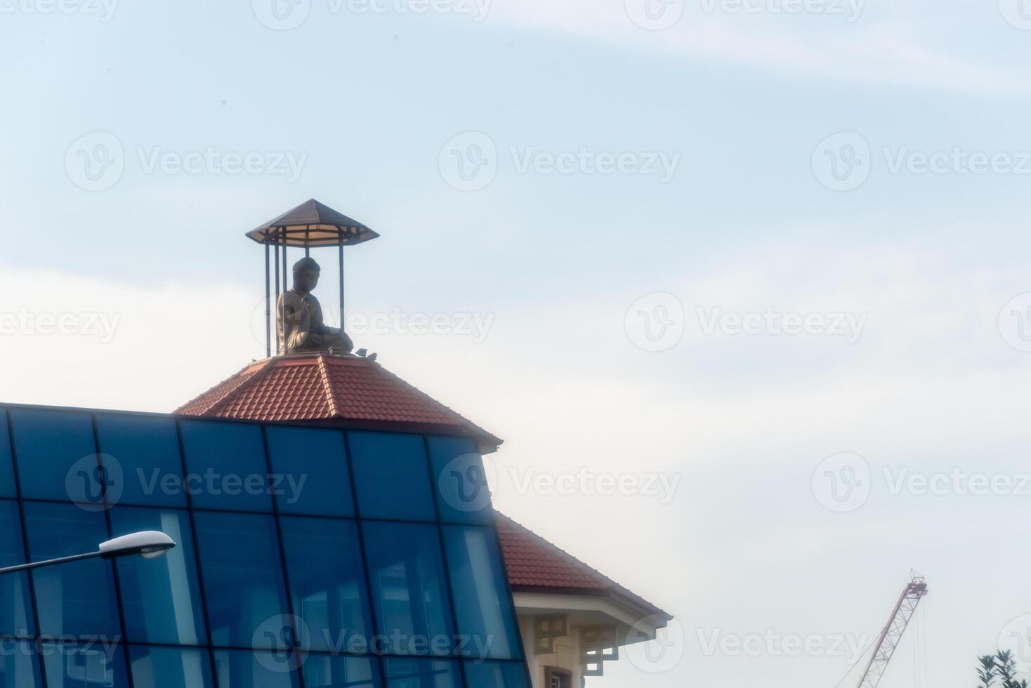 A building with a clock tower and a statue on top photo