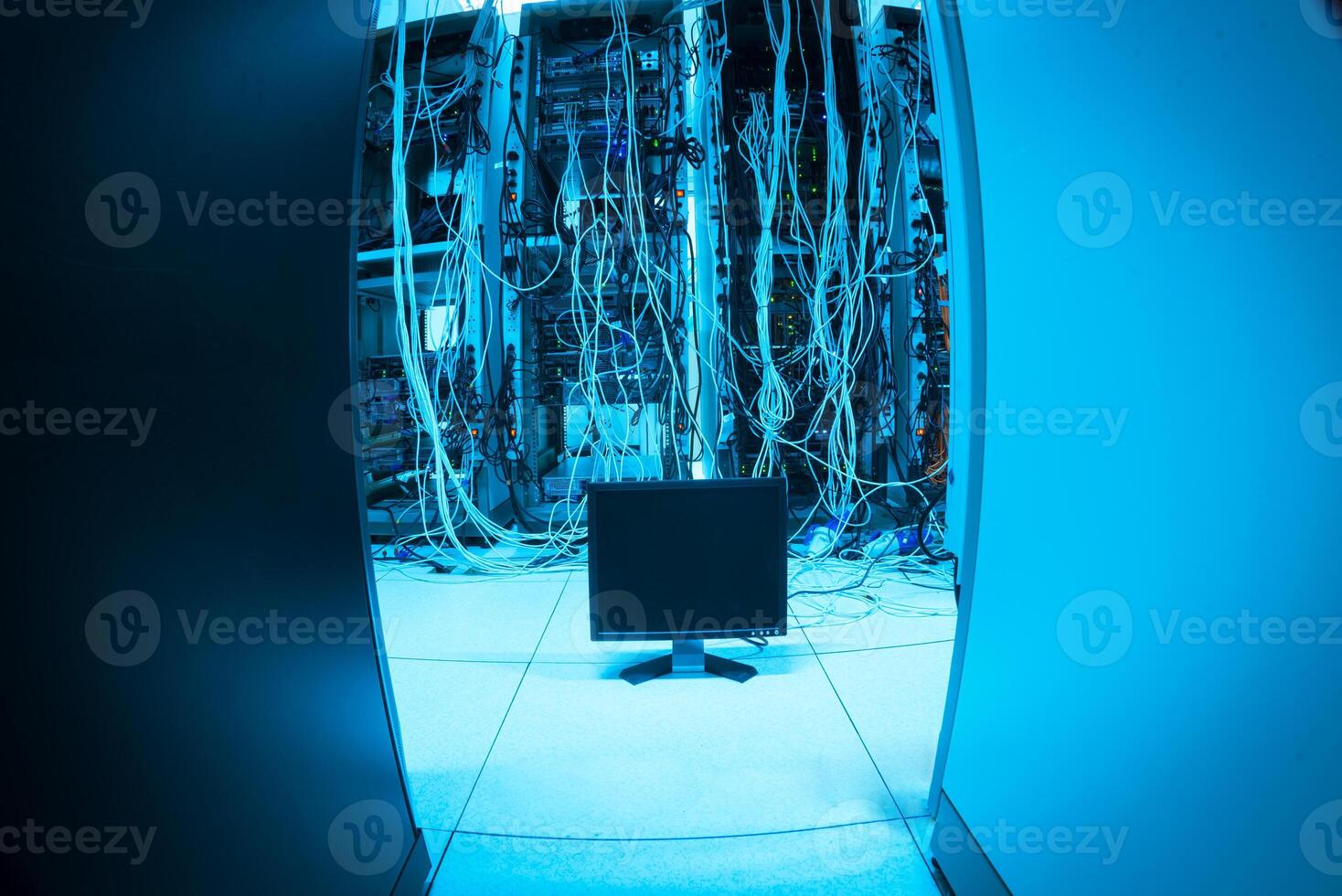 A computer monitor in a dark room with wires photo