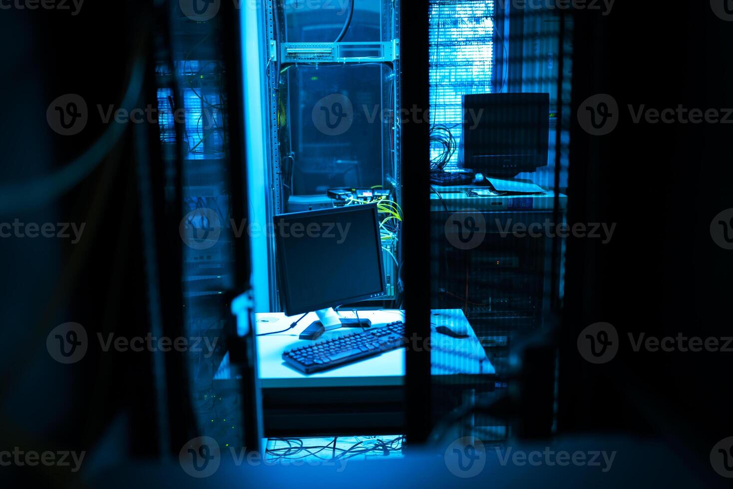 A computer monitor sitting on a desk in a dark room photo