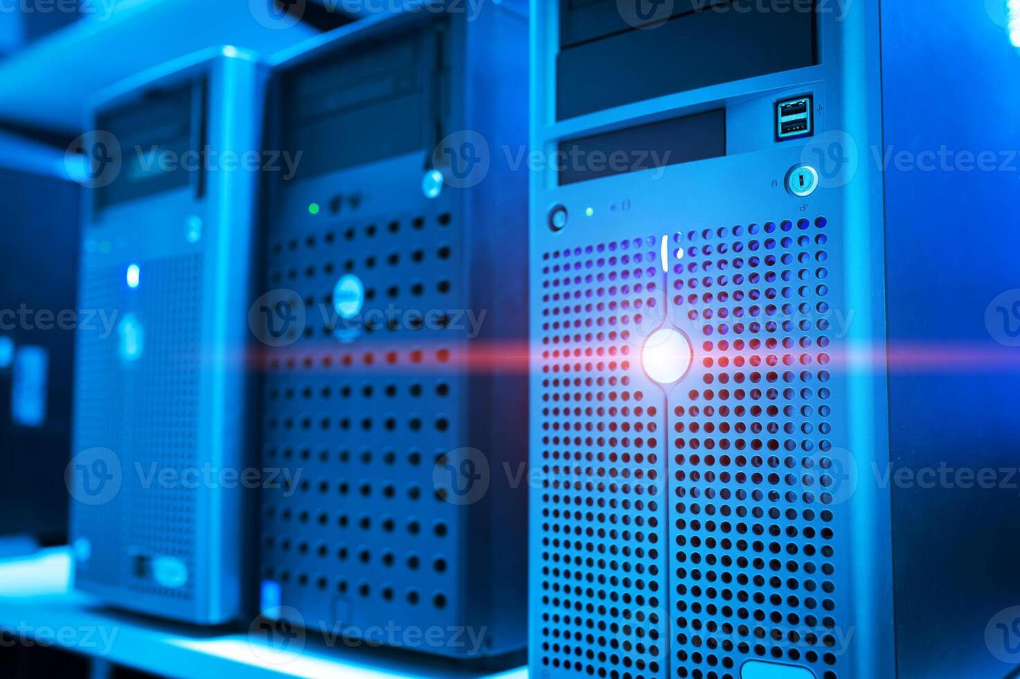 A row of computer servers with a red light shining on them photo