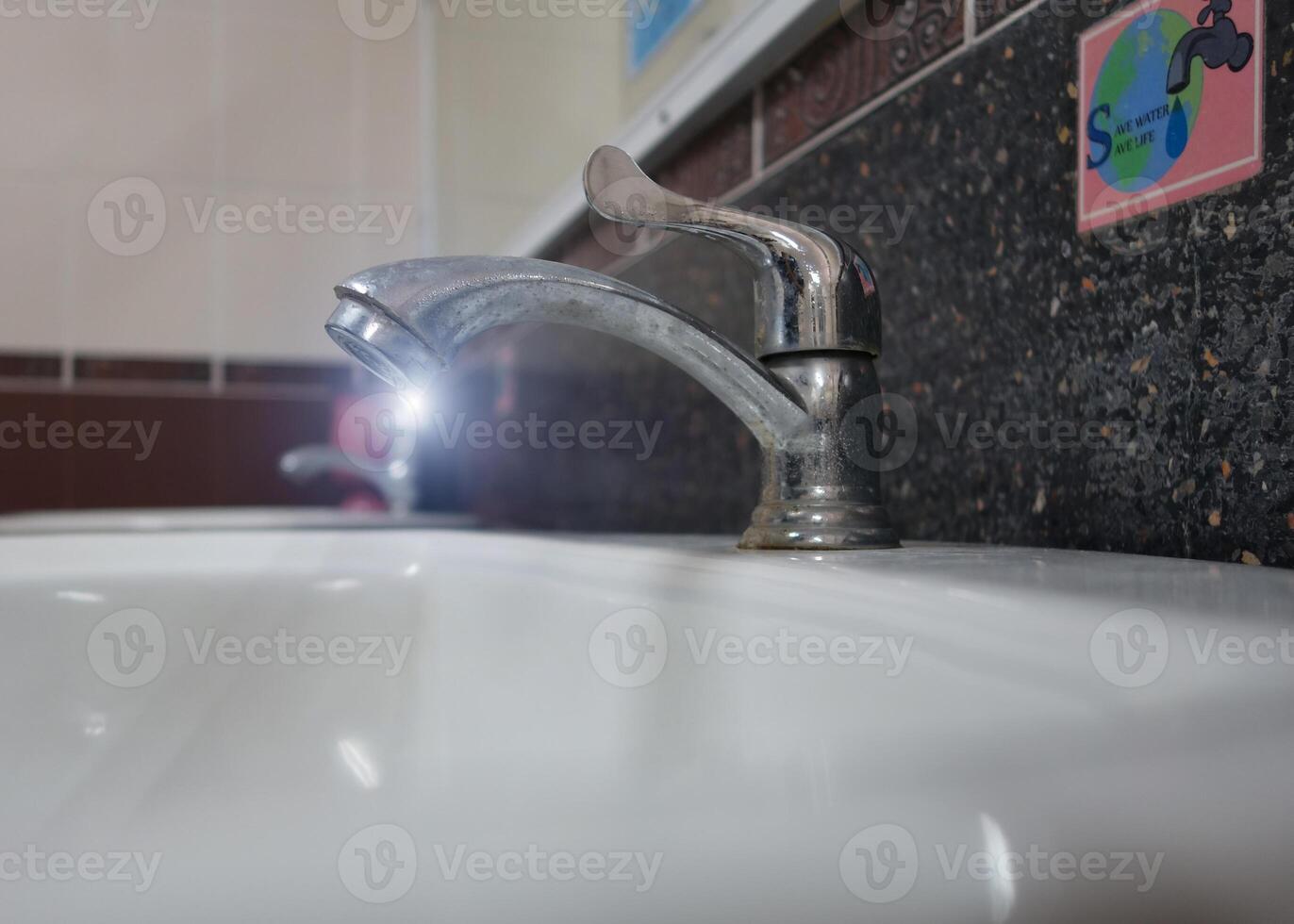 A sink with a faucet and a mirror photo