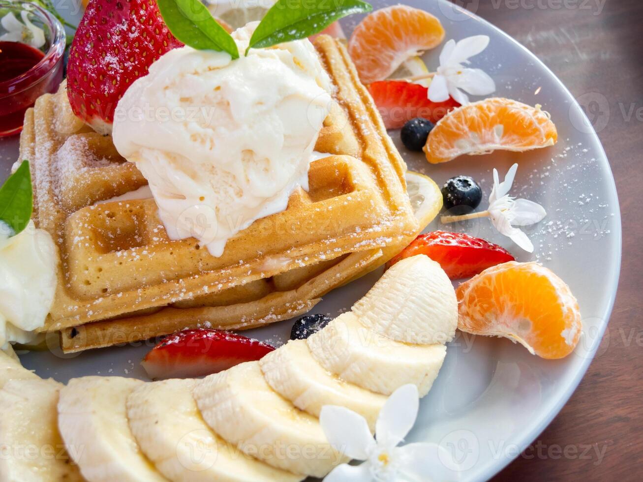 A plate of waffles with fruit and ice cream photo