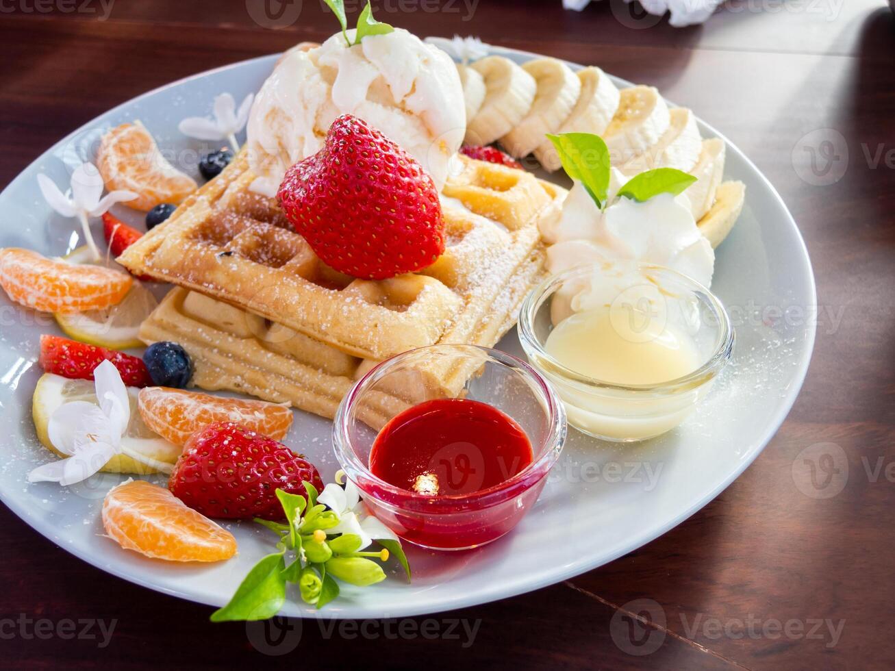 A plate of food with fruit and waffles on it photo