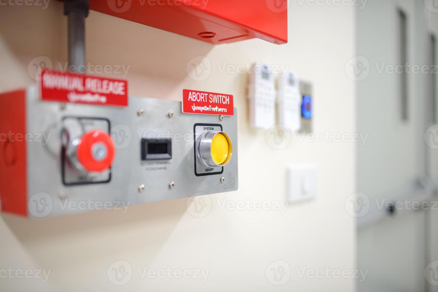 A red and white fire alarm mounted on a wall photo