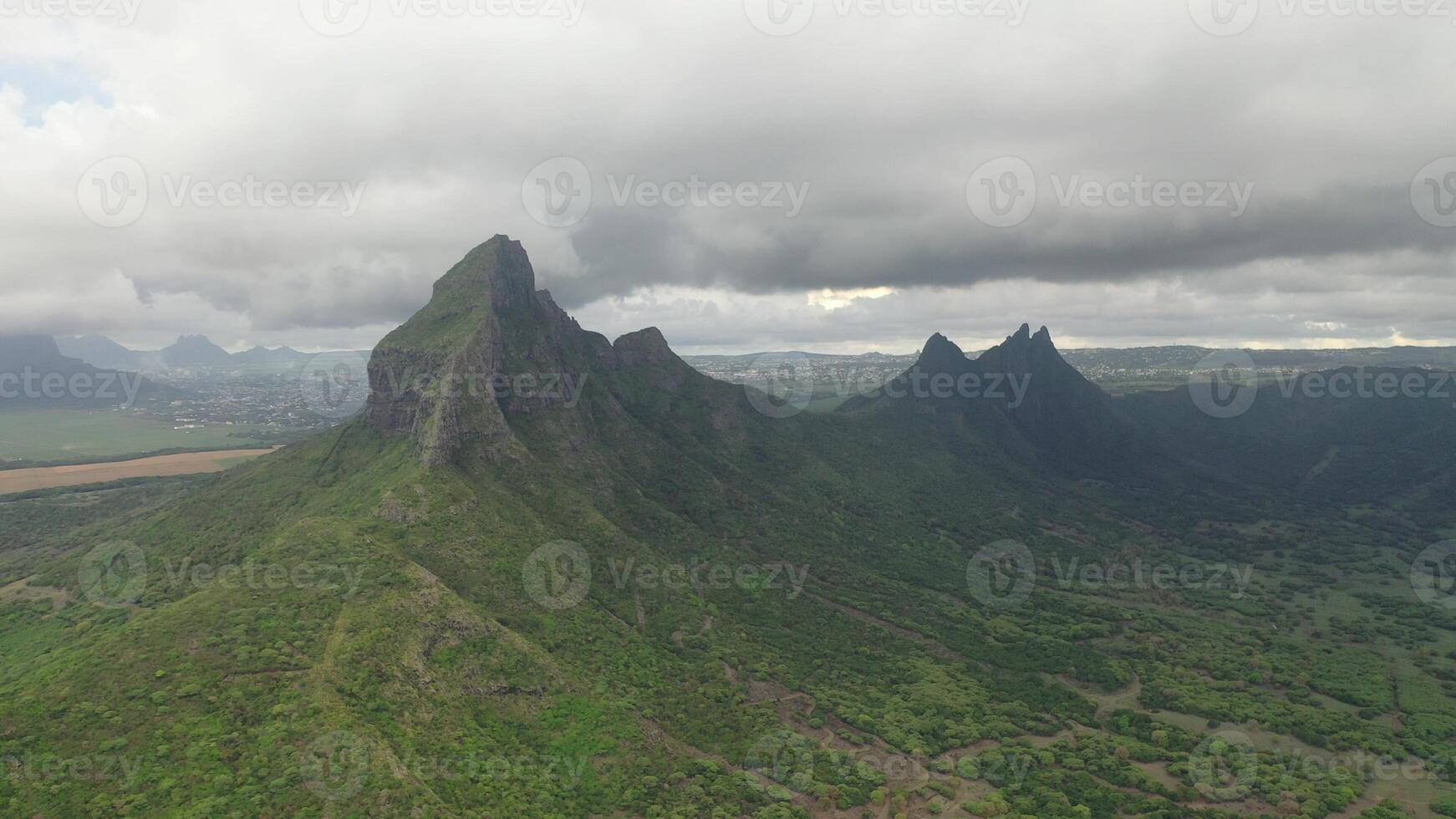 shooting from top to bottom the peaks of mountains and jungles of Mauritius, the sky in clouds photo