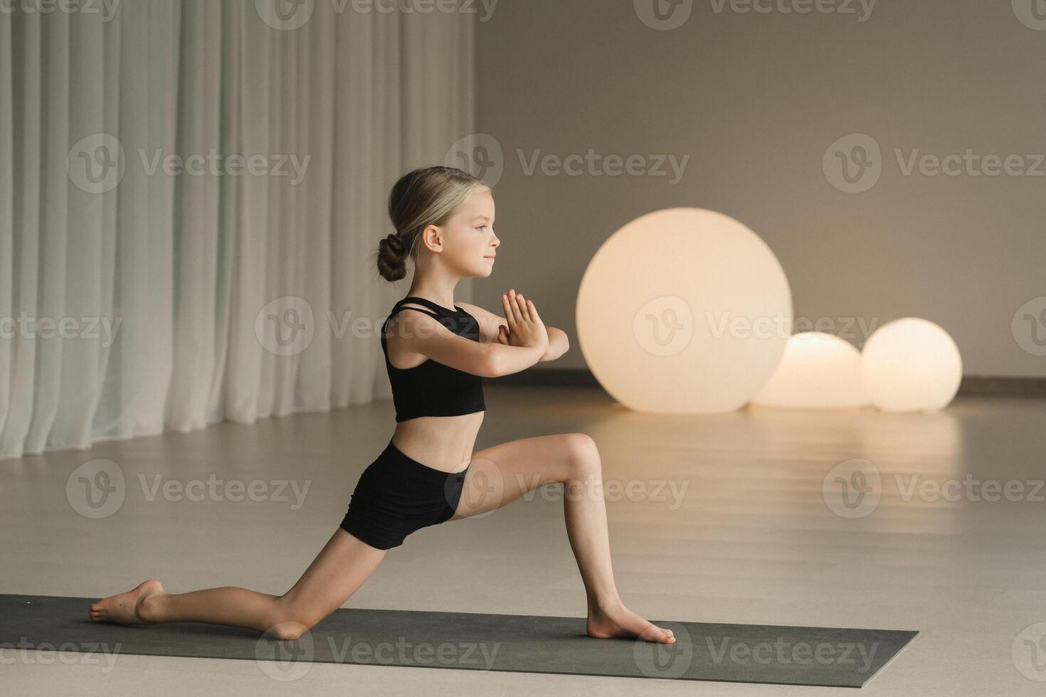 A child practices yoga poses indoors. Children's yoga photo