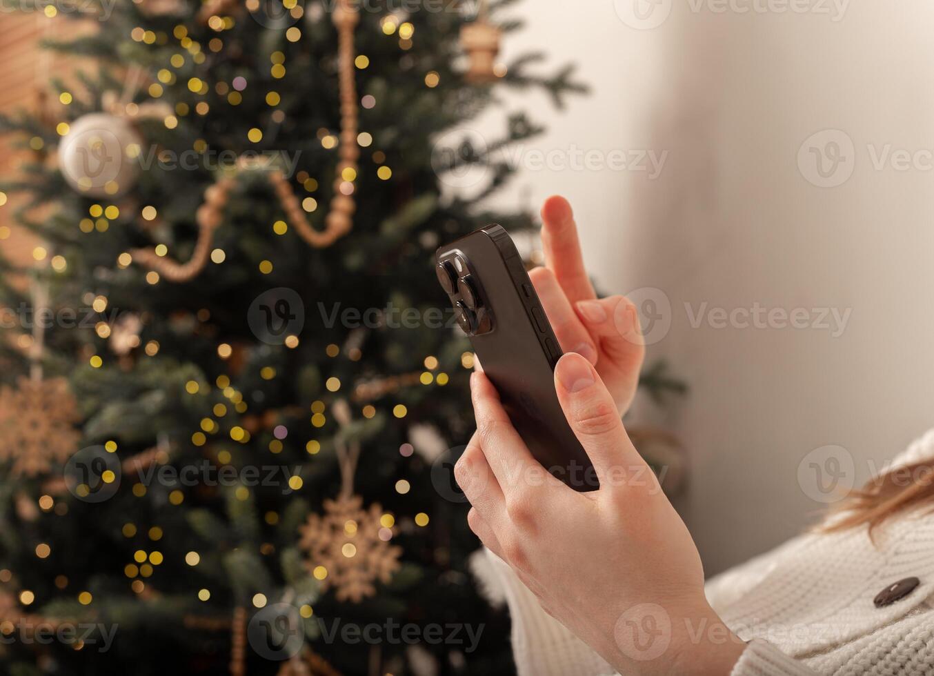 Lodz Poland July 20 2024, hands holding and using mobile phone, iphone smartphone on Christmas photo