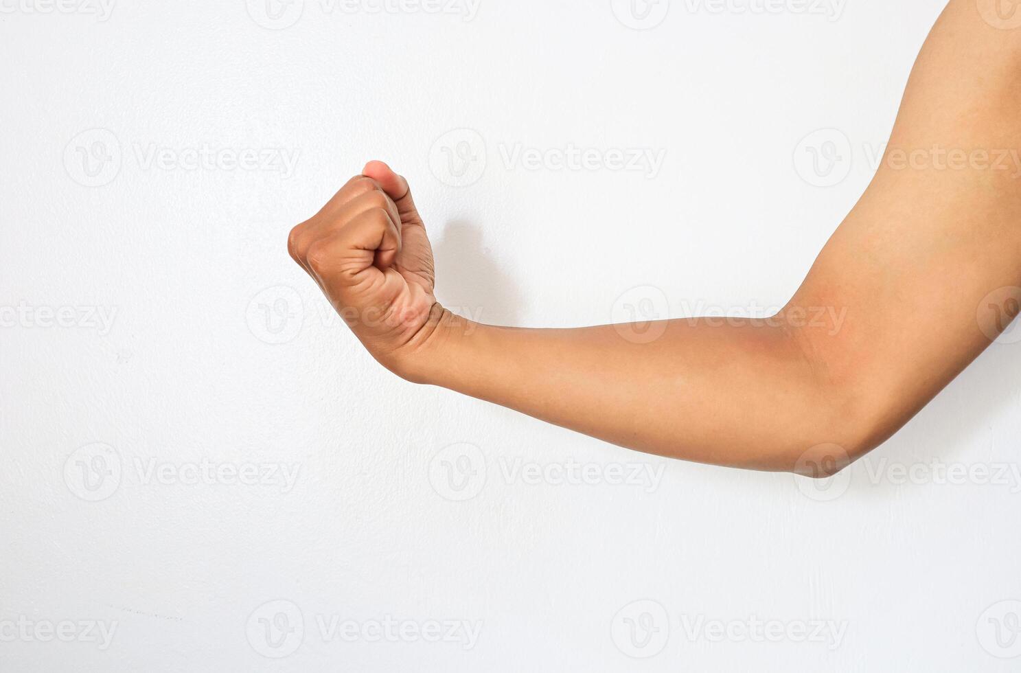 A man's arm is flexing in front of a white wall photo