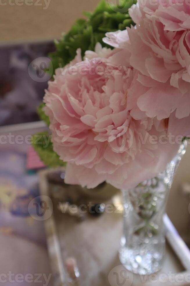 Bouquette of Pink peony and green hydrangea in vase on the table close up photo