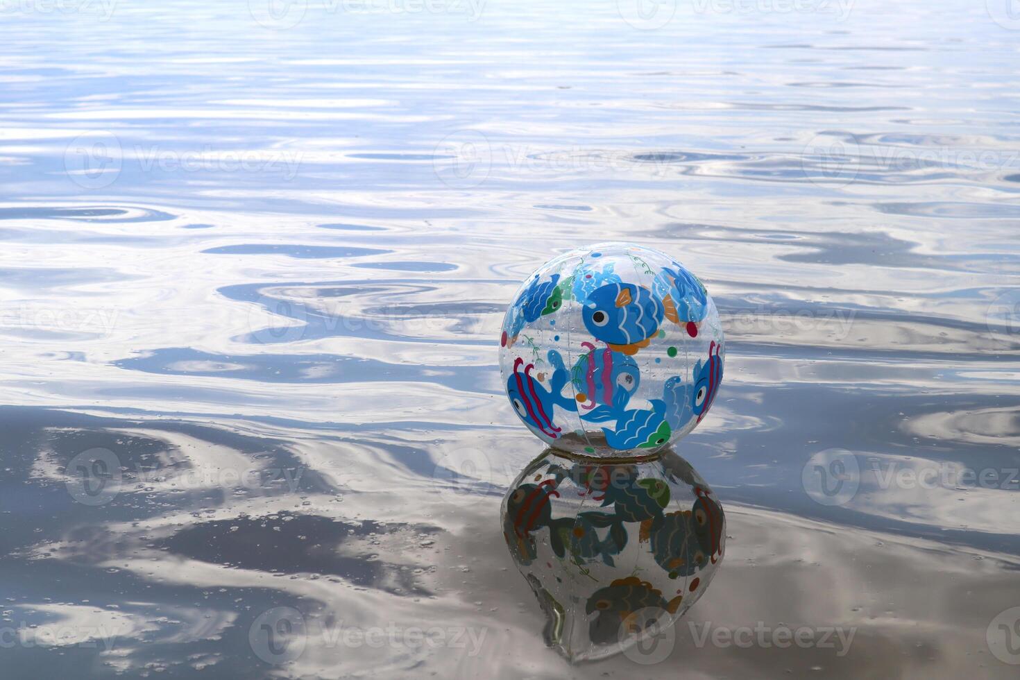 Beach ball on the water surface with place for text. photo