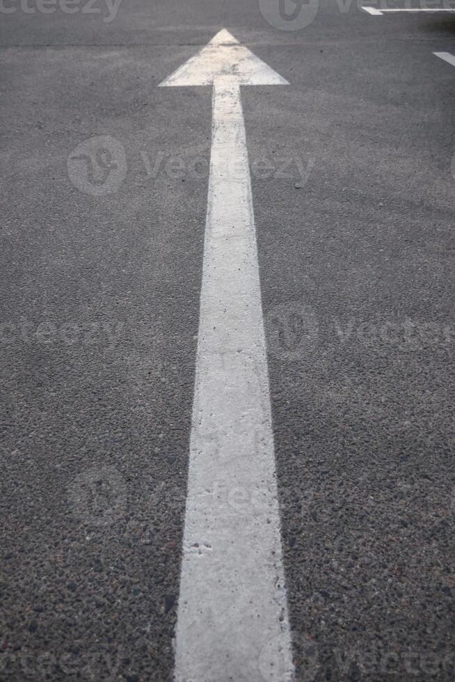 Macro photography of asphalt road texture with vertical arrow close up photo