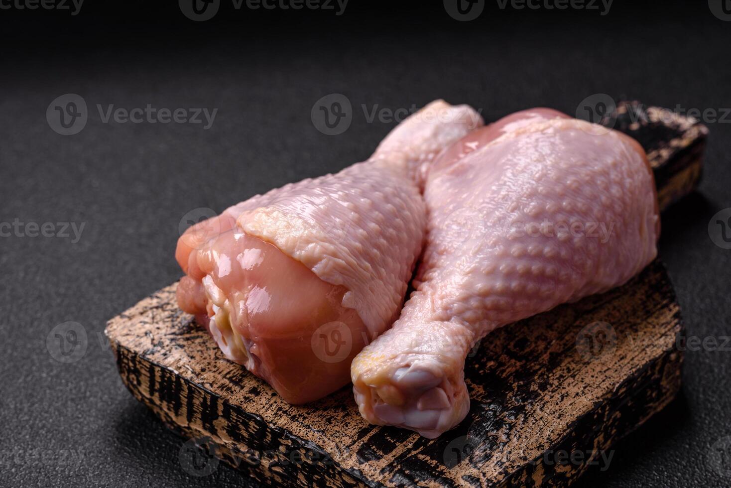 Raw chicken legs with salt, spices and herbs photo