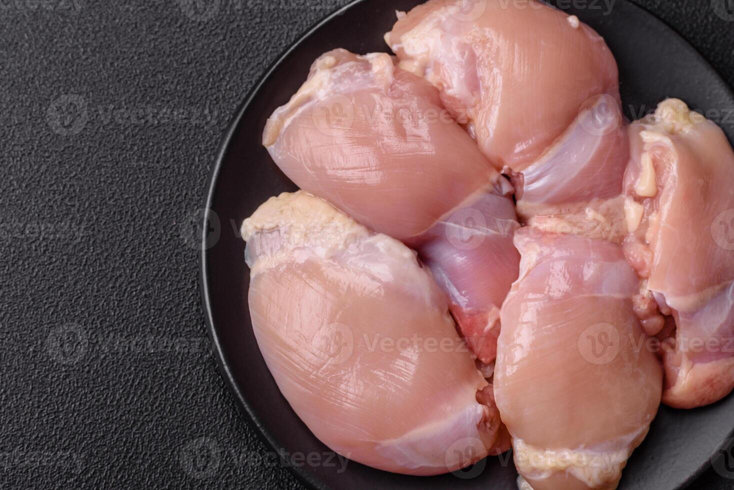 Fresh raw chicken thigh fillets with salt, spices and herbs photo