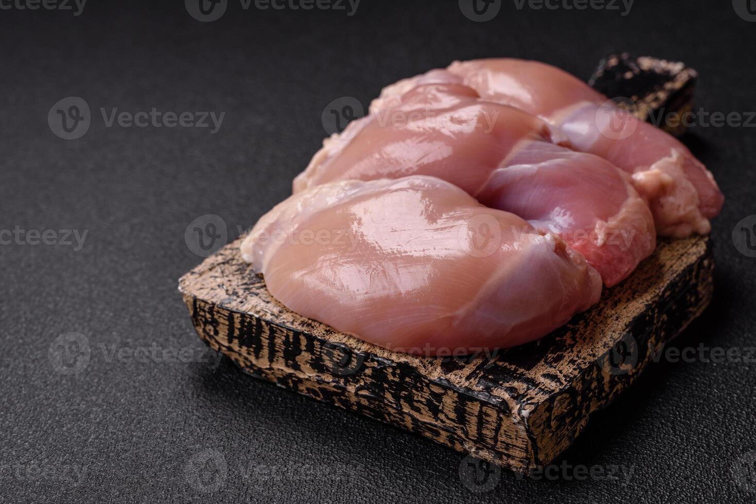 Fresh raw chicken thigh fillets with salt, spices and herbs photo