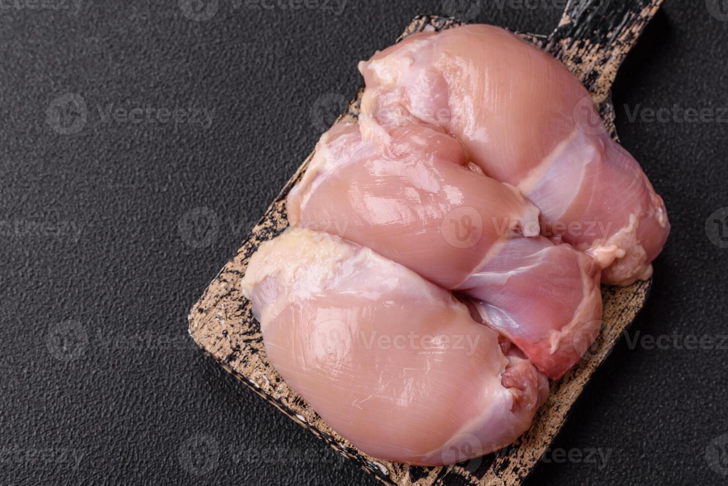 Fresh raw chicken thigh fillets with salt, spices and herbs photo