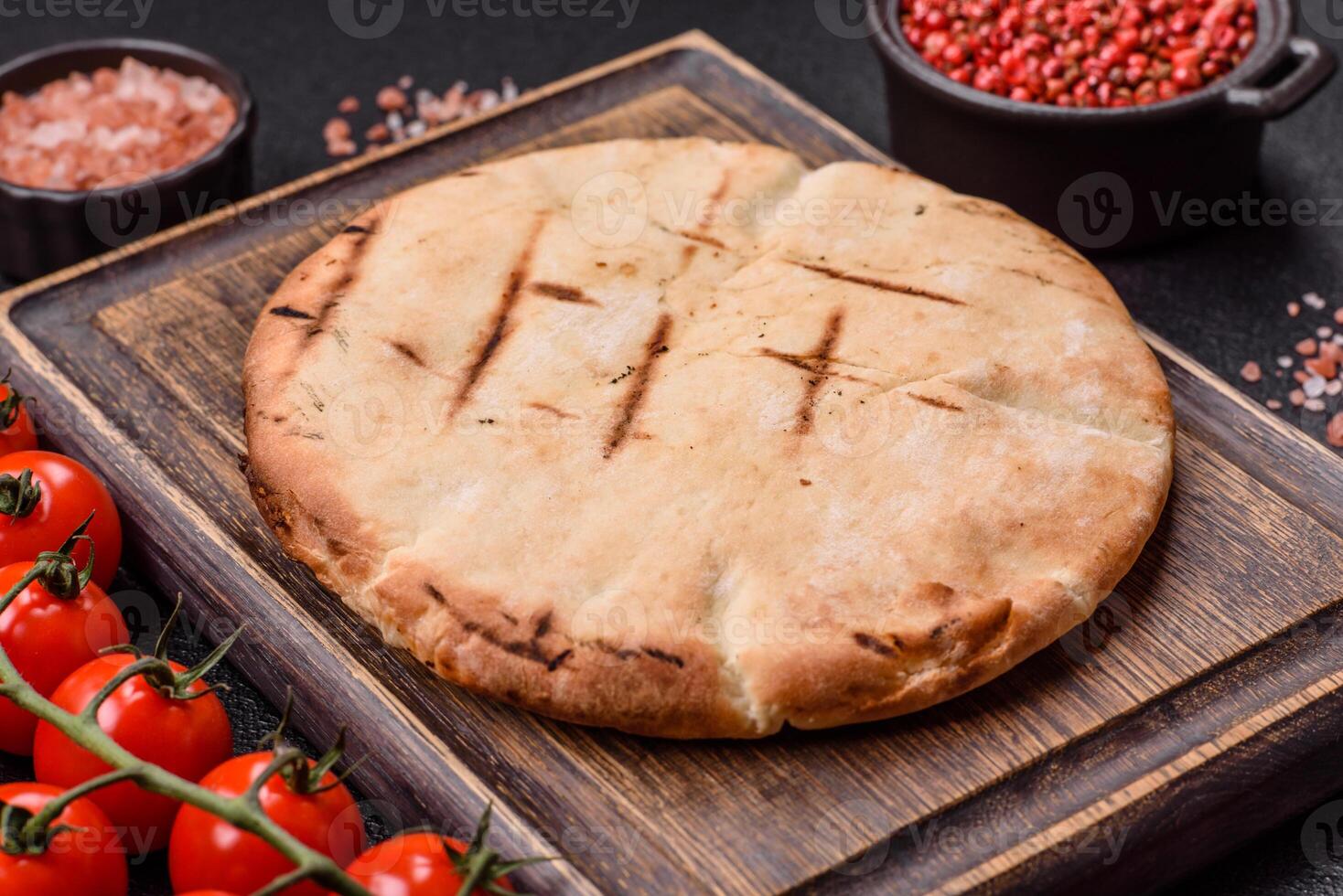 Round flatbread or pita with cheese, herbs, salt and spices photo