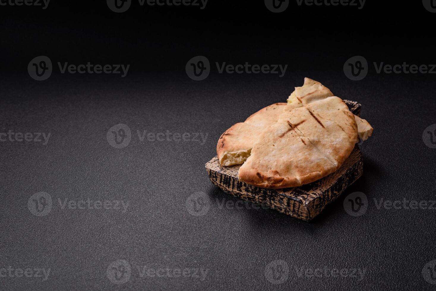 Round flatbread or pita with cheese, herbs, salt and spices photo