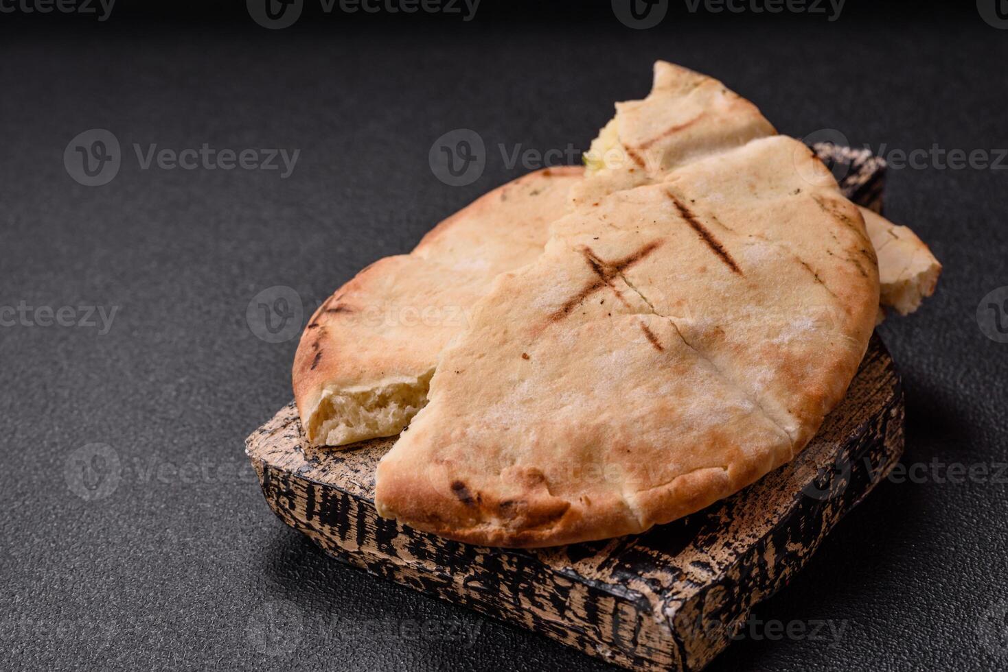 Round flatbread or pita with cheese, herbs, salt and spices photo