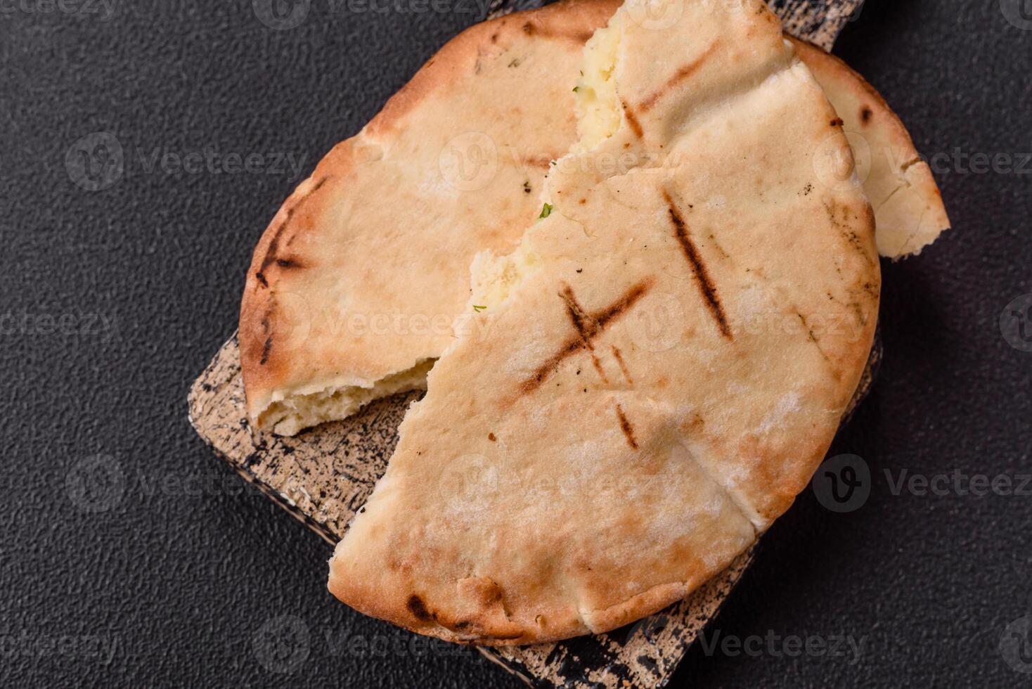 Round flatbread or pita with cheese, herbs, salt and spices photo