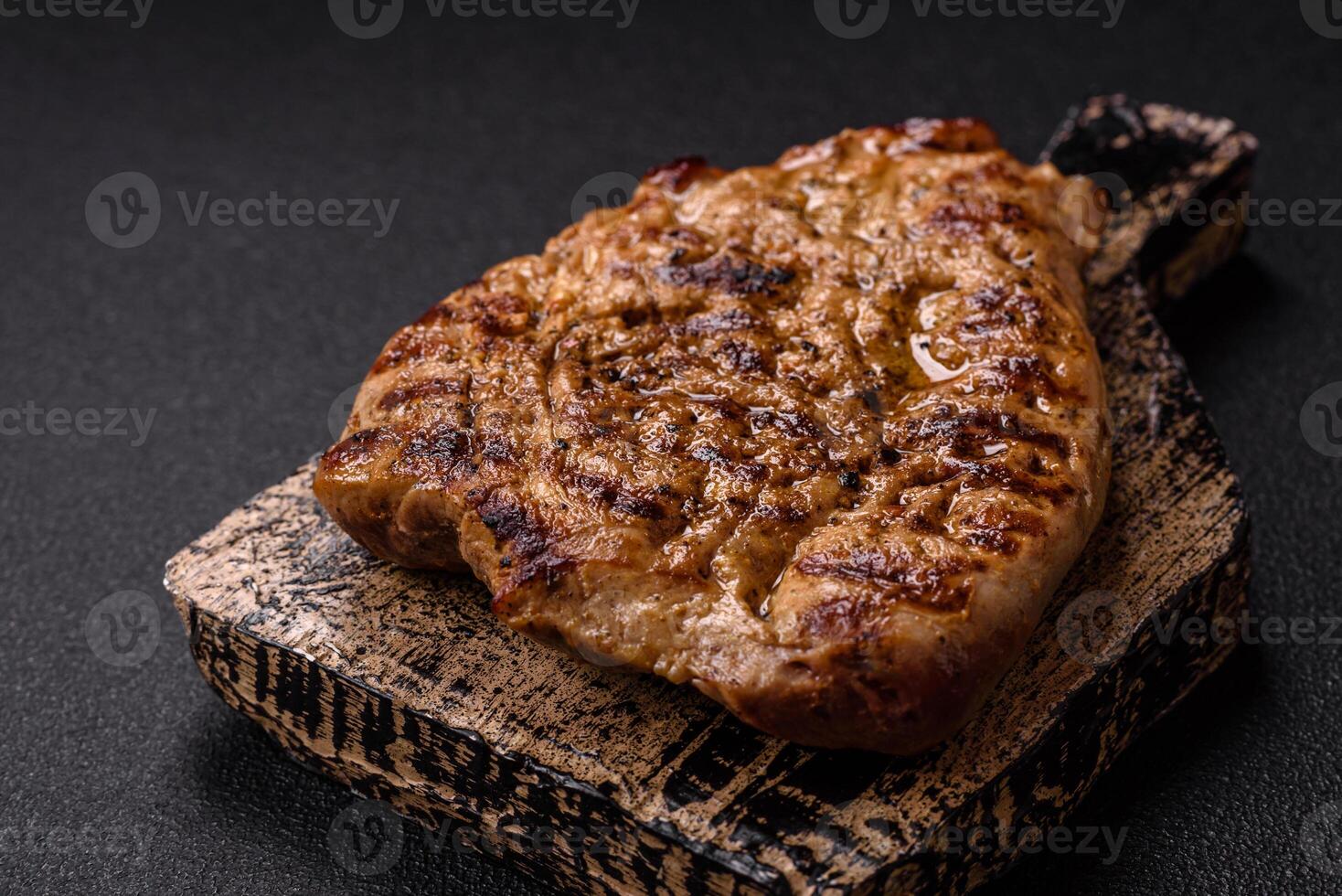 Grilled beef or pork steak with salt, spices and herbs photo