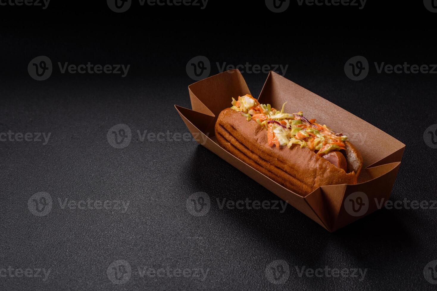 Hotdog with grilled sausage with cabbage, carrots and onions photo