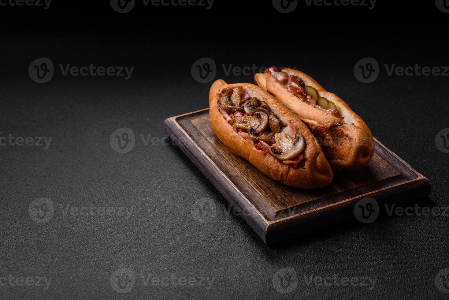 Hotdog with grilled sausage with bacon and mushrooms photo