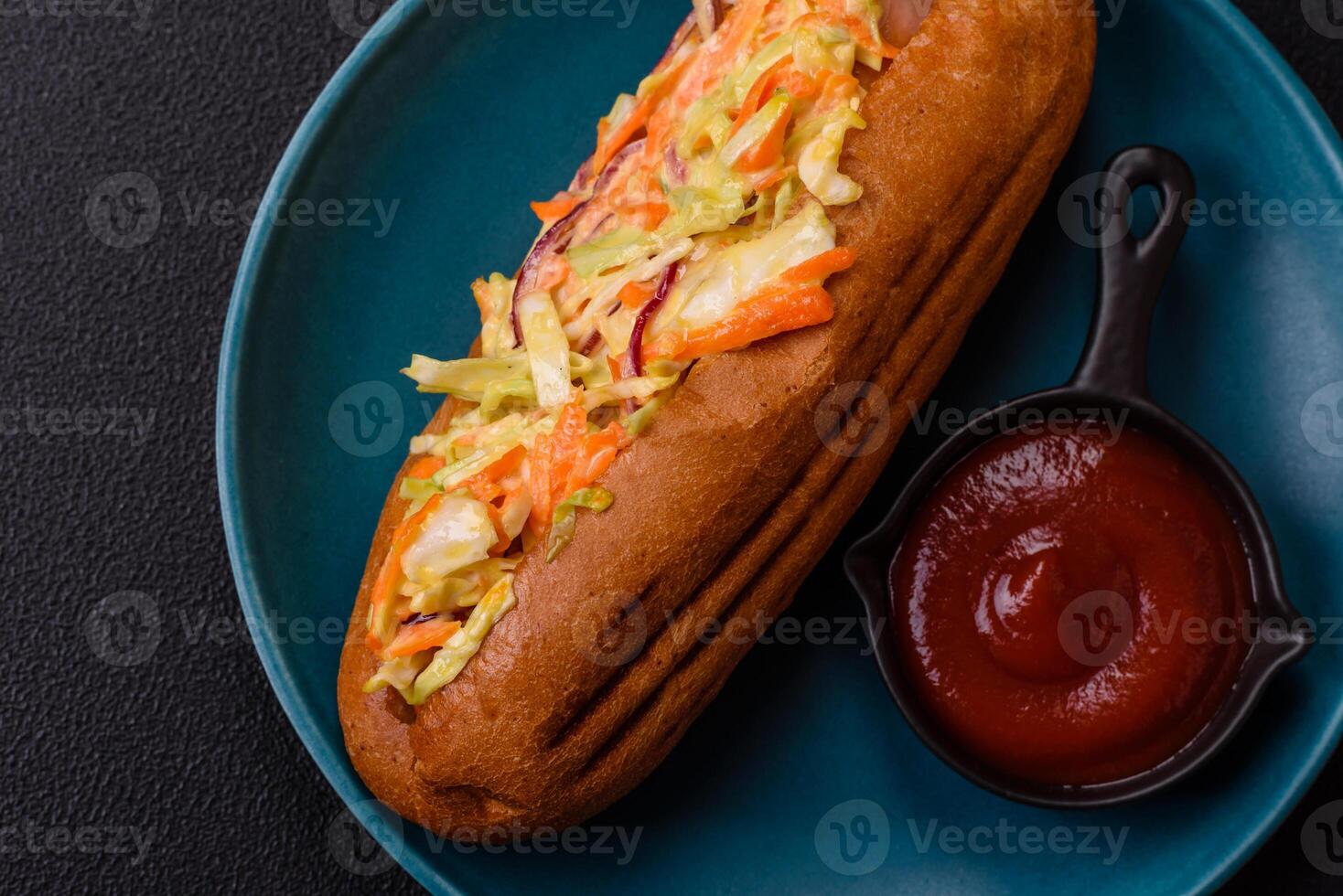 Hotdog with grilled sausage with cabbage, carrots and onions photo