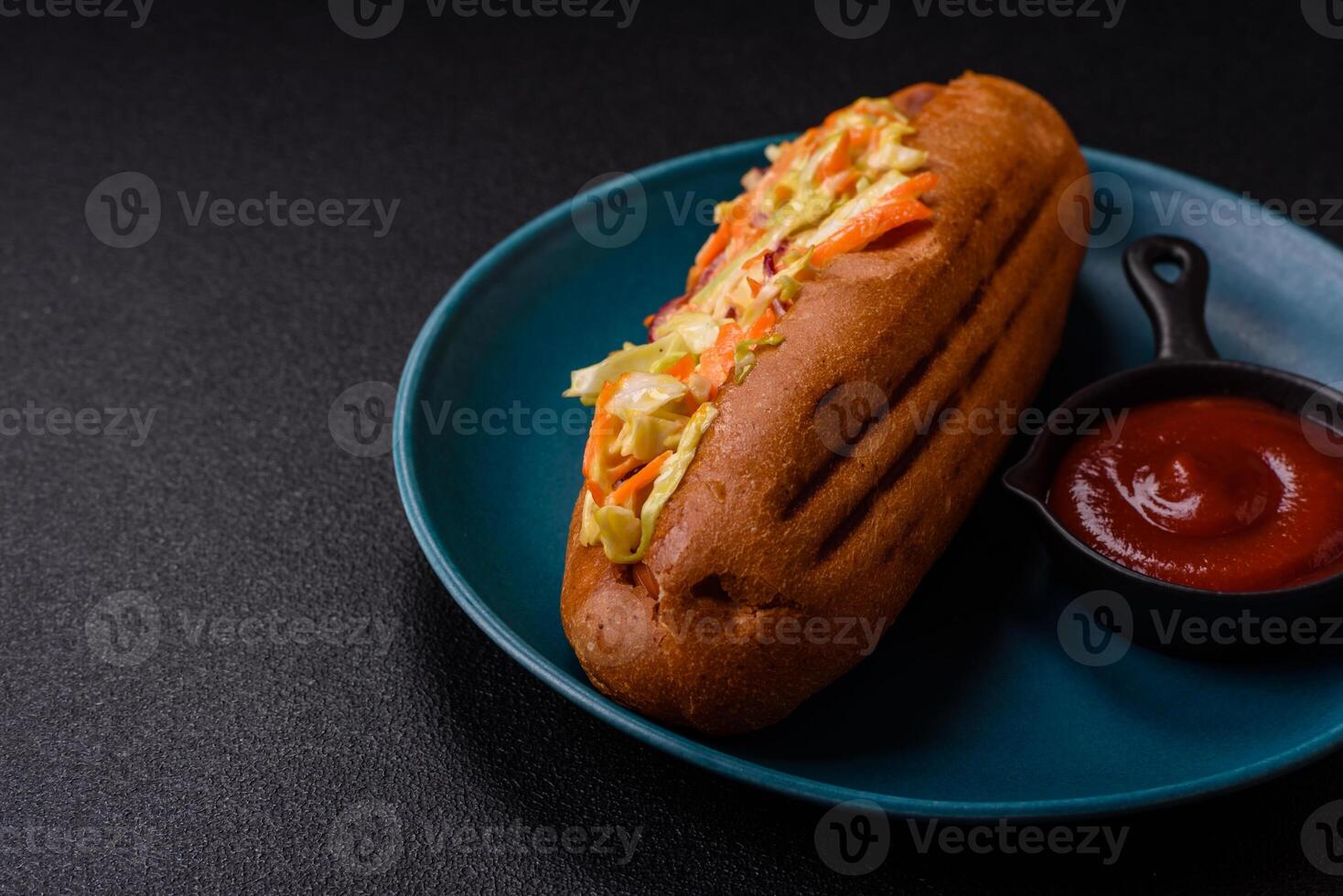 Hotdog with grilled sausage with cabbage, carrots and onions photo