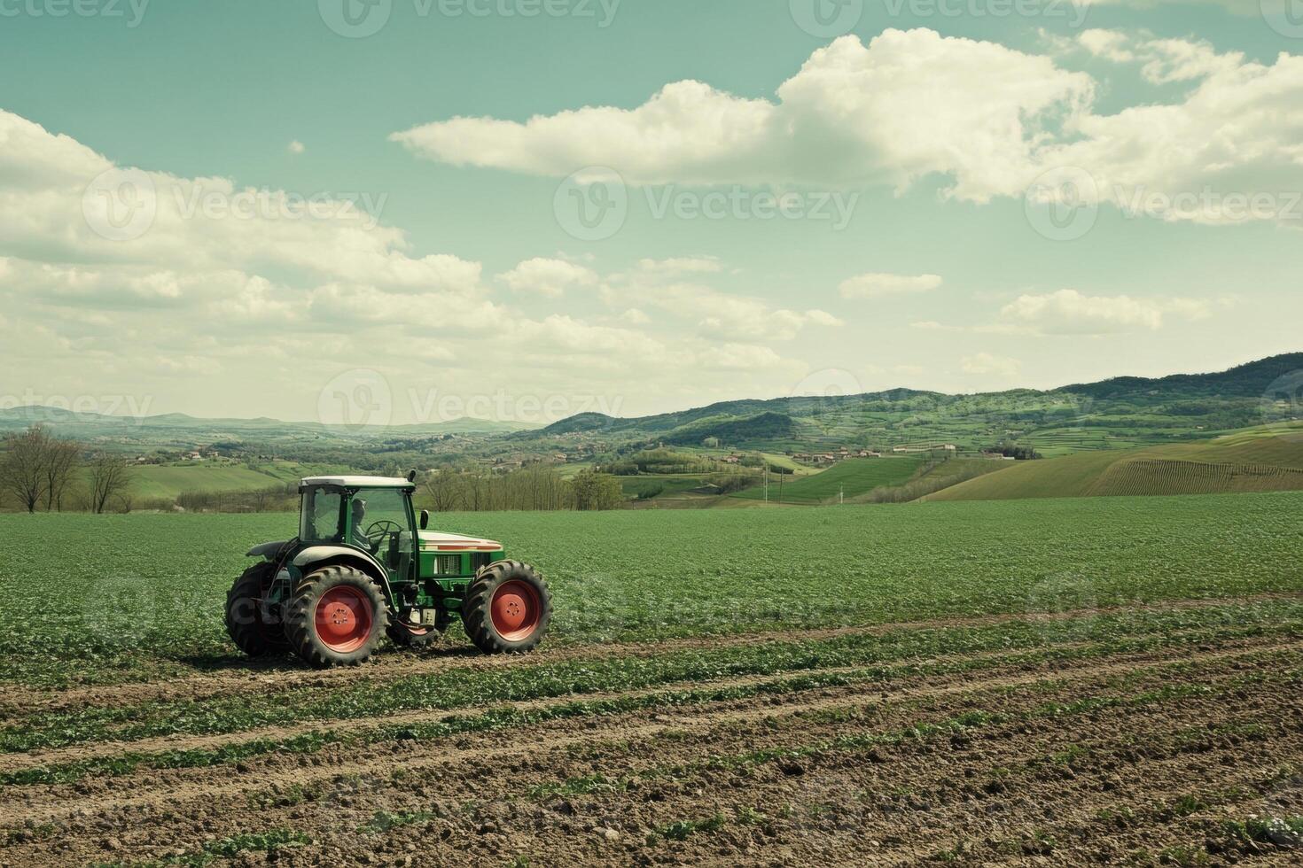 Farmer driving tractor in cultivated field on sunny day photo