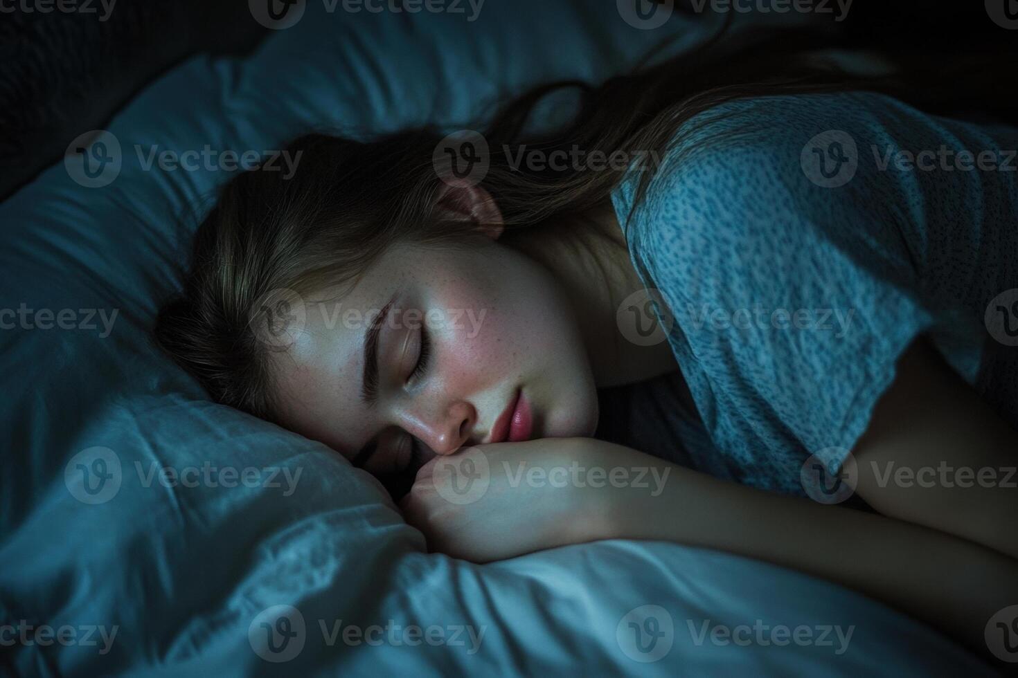 Young woman sleeping peacefully in bed at night photo