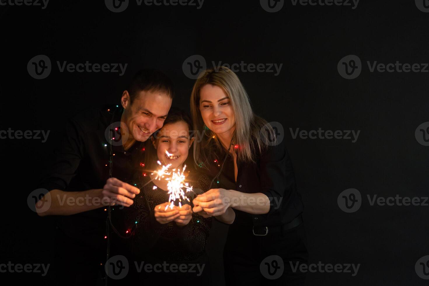 family with sparklers on a black background photo
