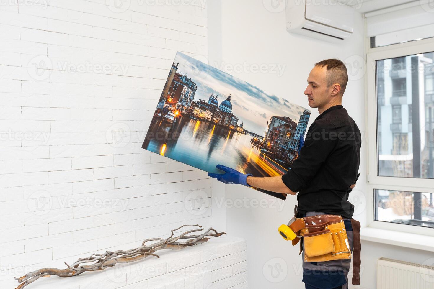 repairman master holds a photo canvas