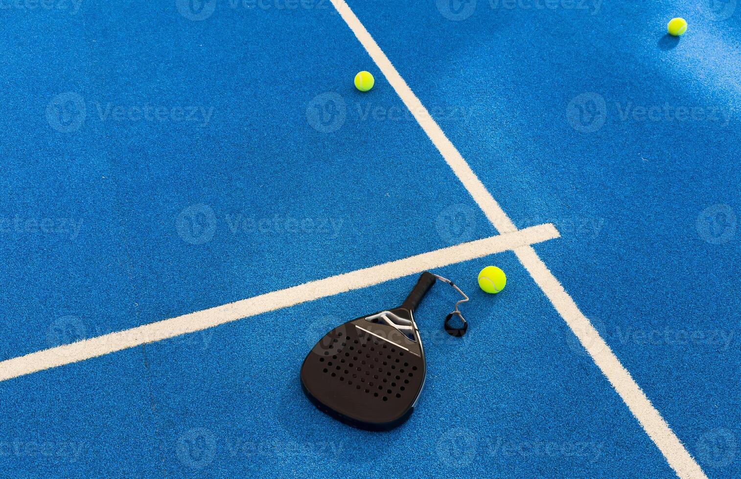 Black professional paddle tennis racket and ball with natural lighting on blue background. Horizontal sport theme poster, greeting cards, headers, website and app photo