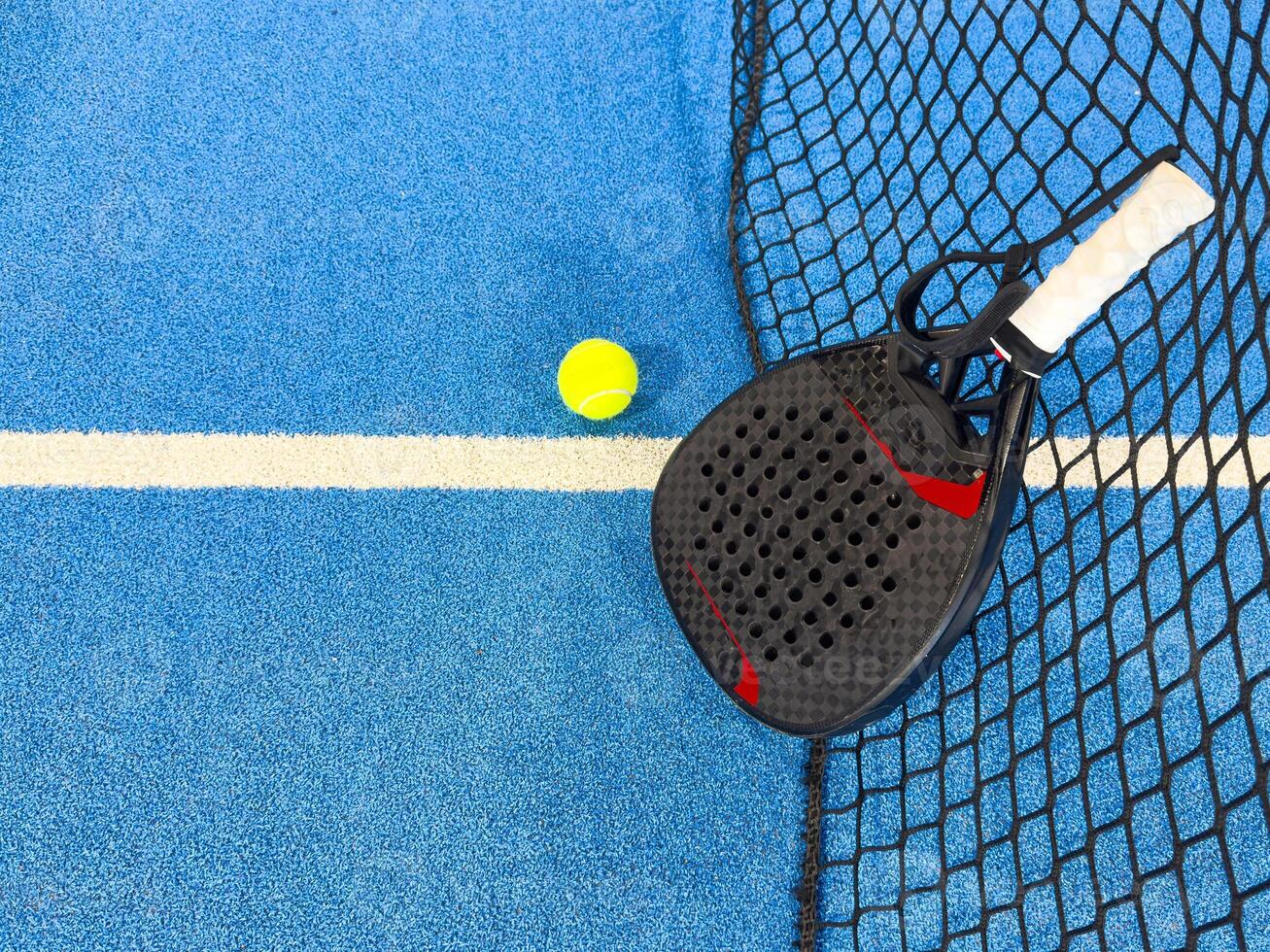 padel racket on a padel blue court with a ball photo