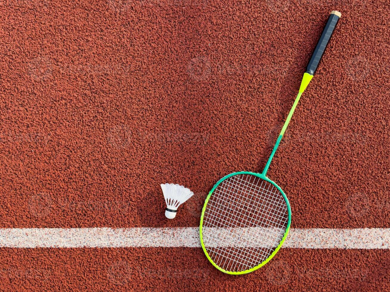 Cream white badminton shuttlecock and racket on badminton court, copy space, soft and selective focus. photo