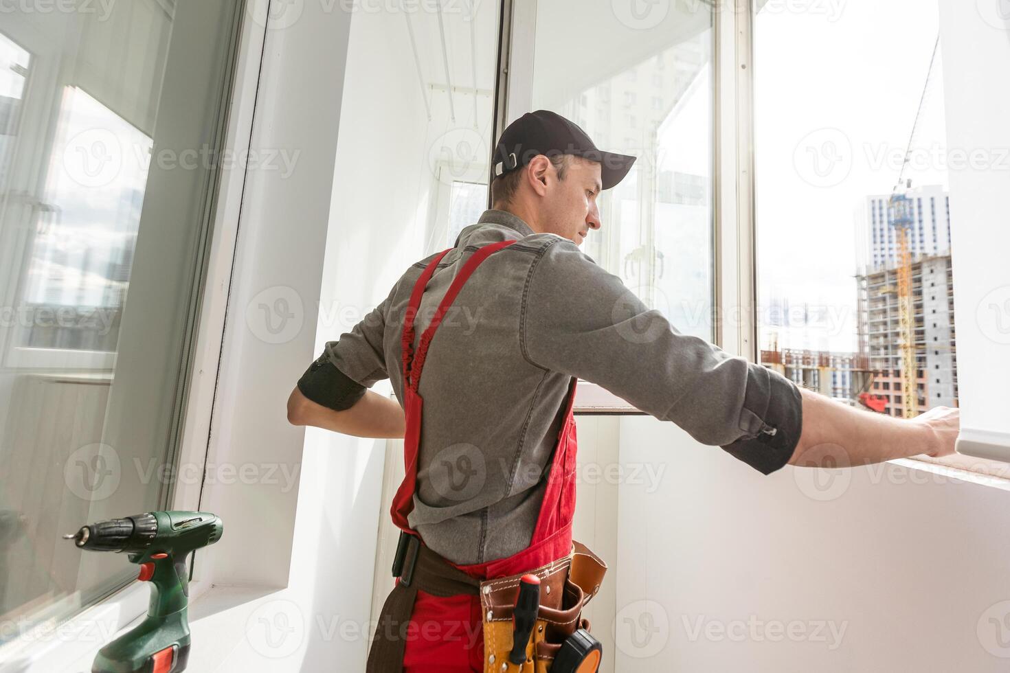 male industrial builder worker at window installation in building construction site photo