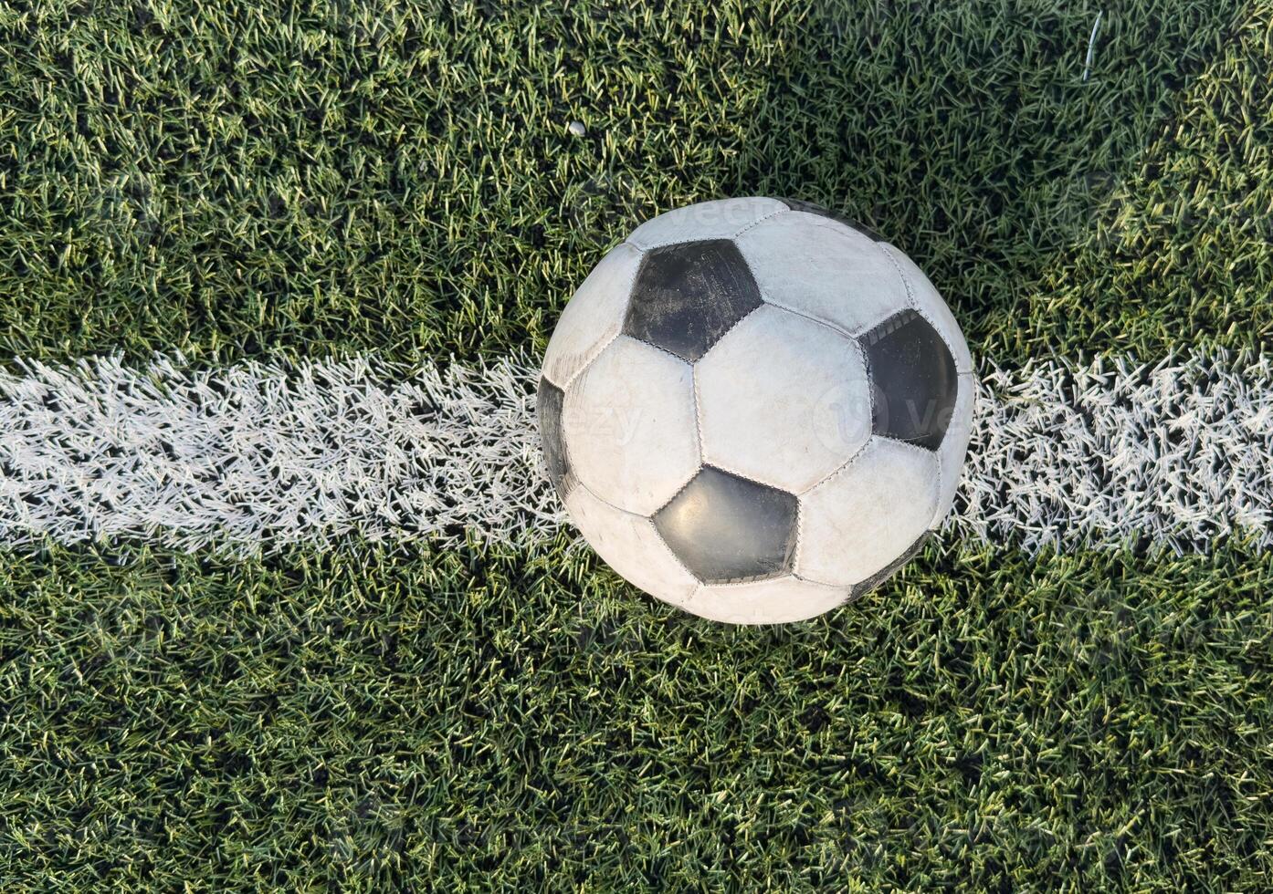 top view of football on green field, soccer ball on grass photo