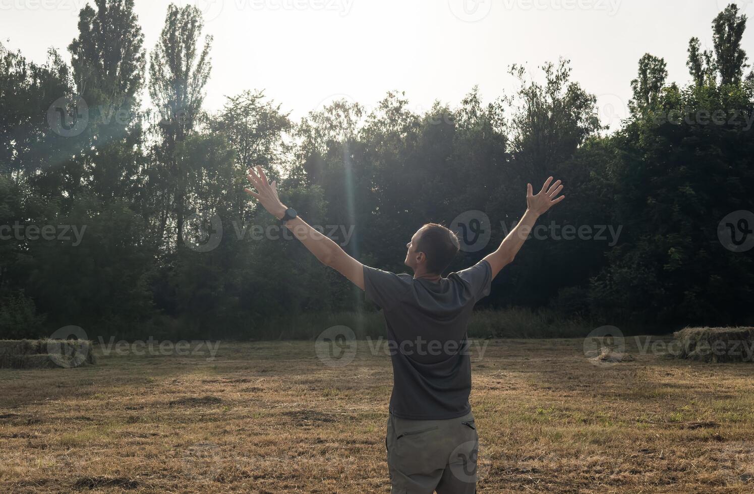 A Man Looking At Sky With Arms Wide Open photo