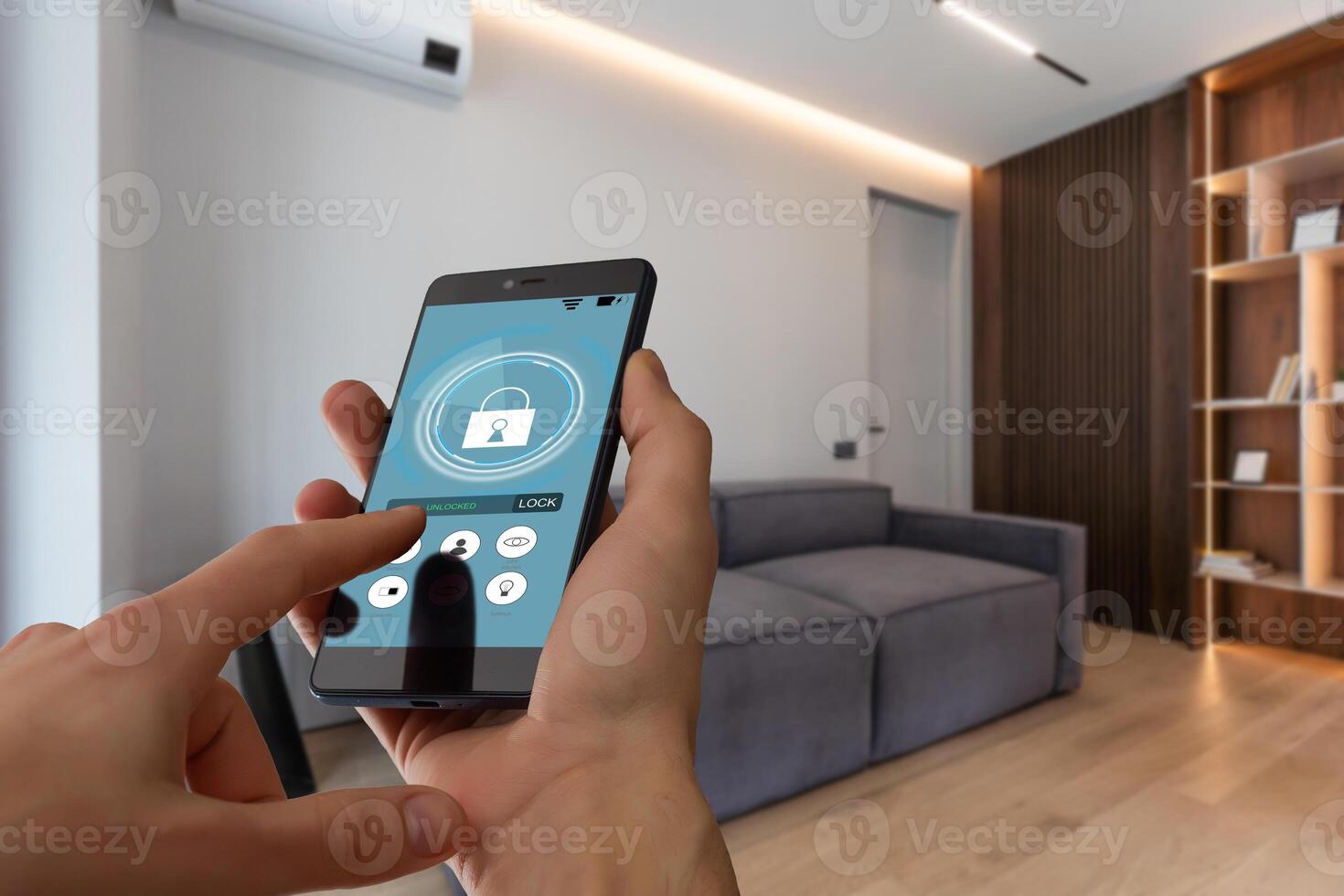 Young woman holding smart phone with launched security application at home. Concept of controlling and managing home security from a mobile device photo