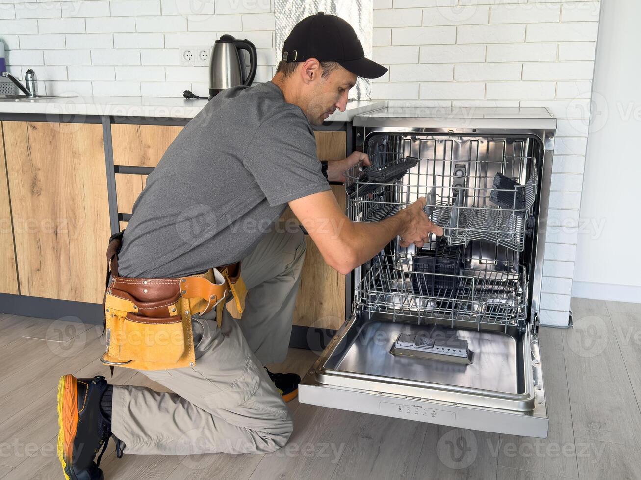 Worker repair dishwasher at home. photo