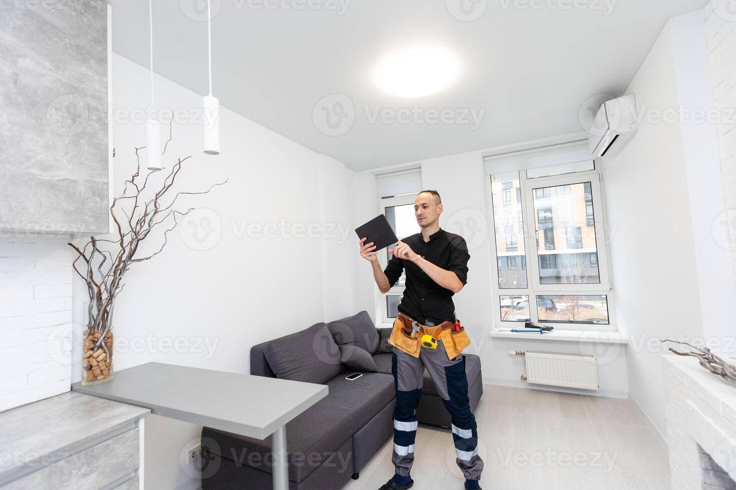 Worker with tablet computer checking alarm system indoors photo