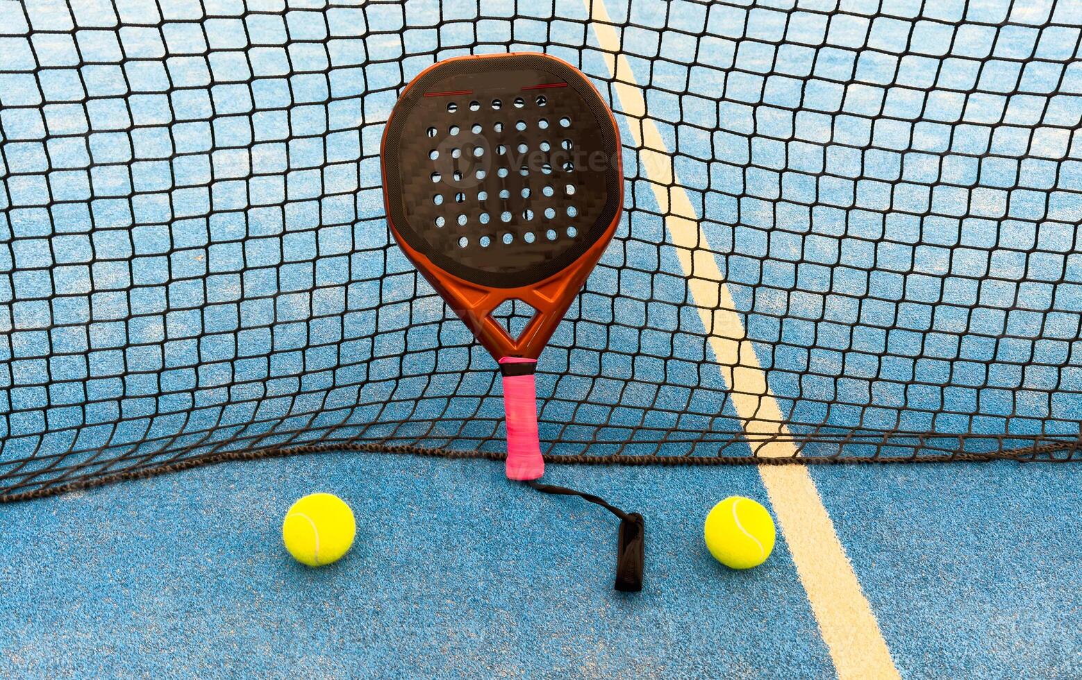 padel racket on a padel blue court with a ball photo