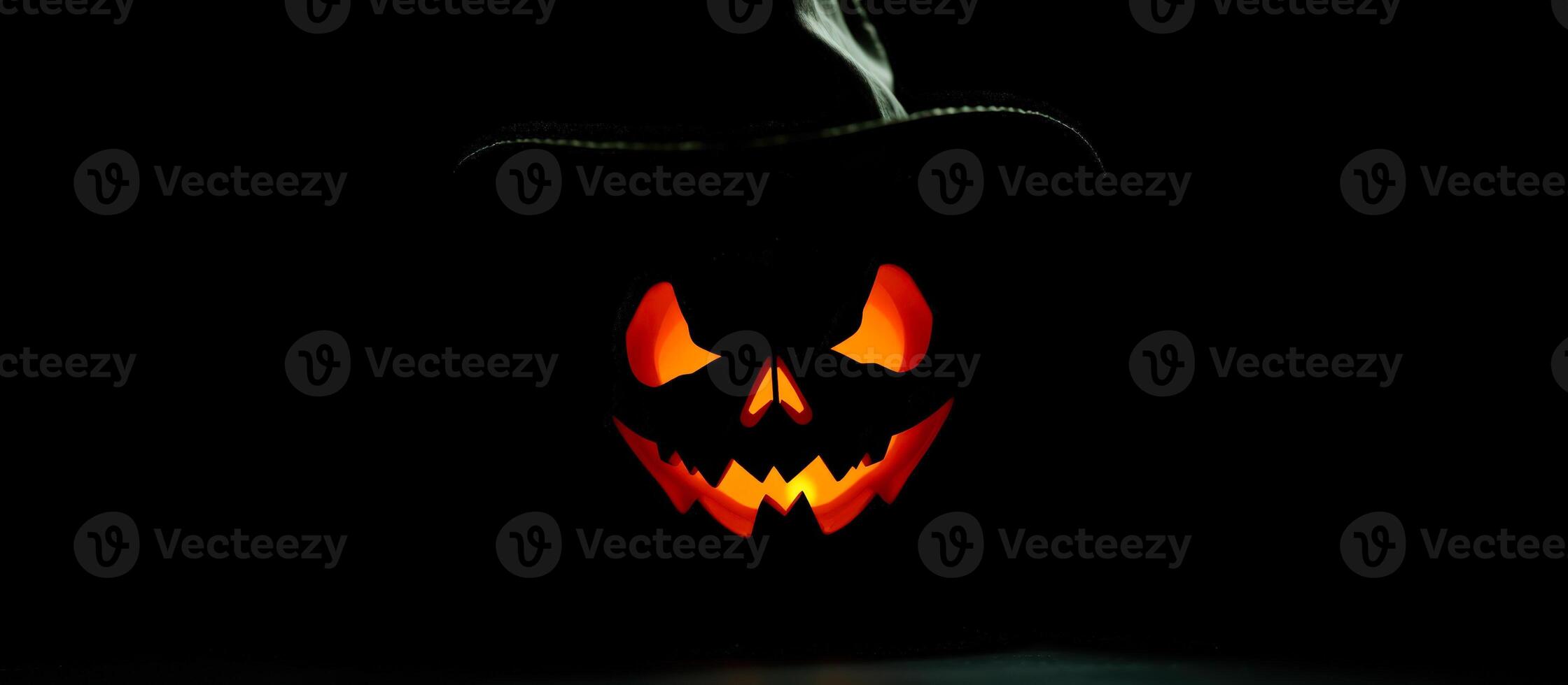 Glowing Jack-o'-Lantern with Hat on Black Background photo